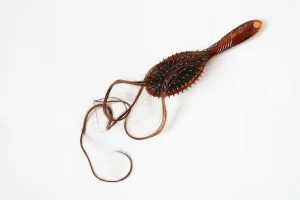 A hairbrush filled with hair. 