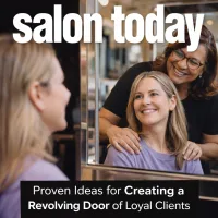 A middle aged stylist gazes into the mirror with a longtime, loyal client, showing the bond the two have formed after the client's many years of loyalty. 