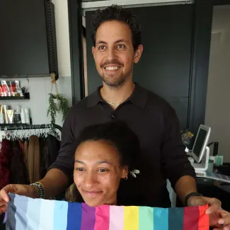 A man holds a piece of fabric in front of a woman's face