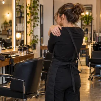 A hairdresser rubs her shoulders.