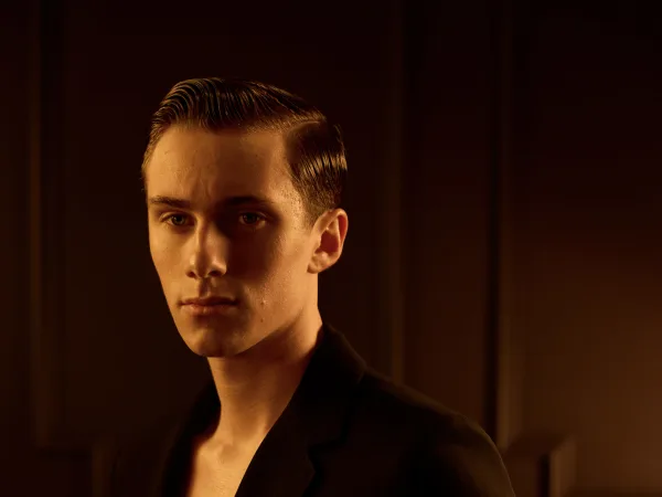 A man with slicked back hair and a suit jacket