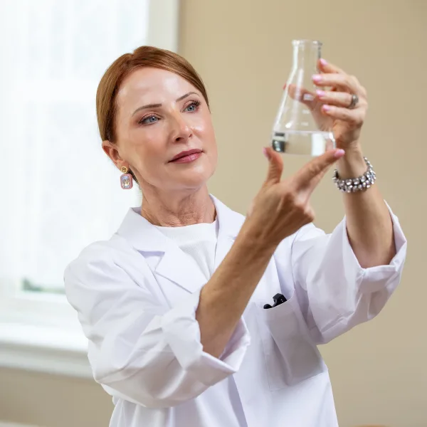 Pharmaceutical Chemist Jennifer Sherak examines a flask
