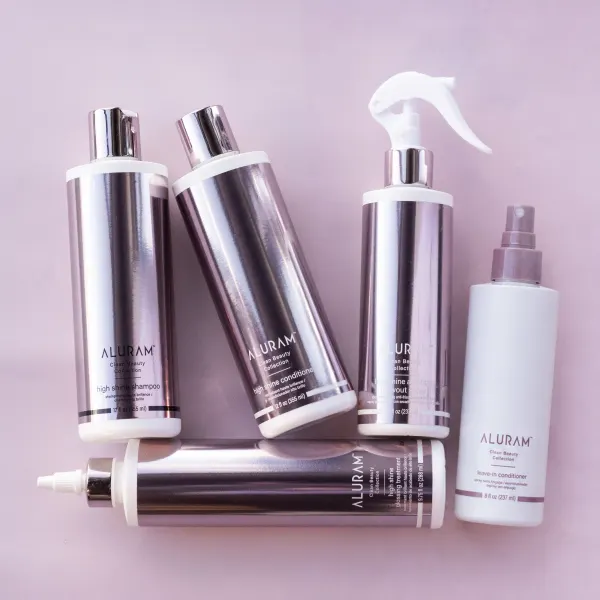 a collection of hair products in shiny pink bottles