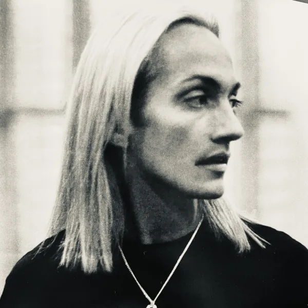A man with long blonde hair in profile.