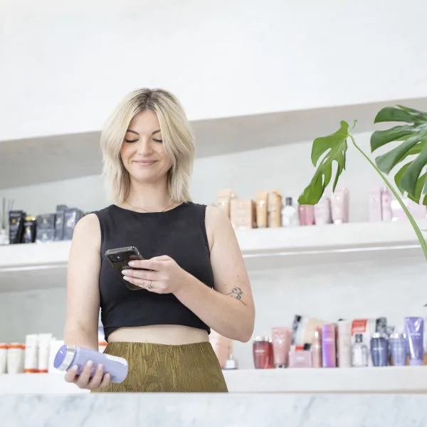 woman in salon scanning product with her phone