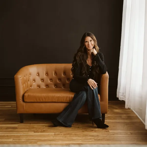 Kati Whitledge sits on a brown couch.