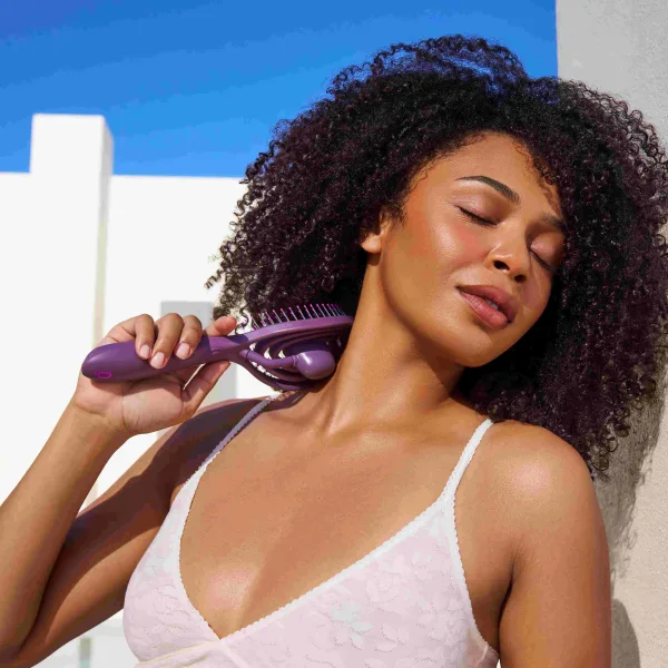 A model brushes her hair with the OO!Brush