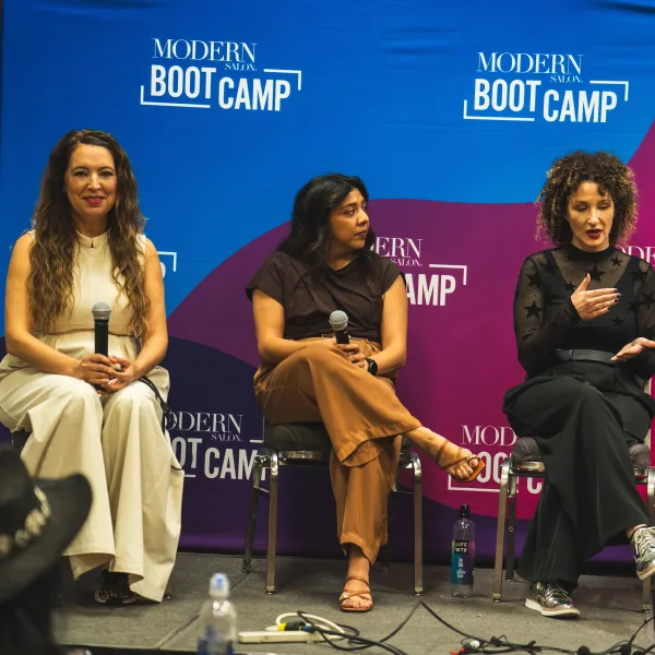 Four women on a stage with microphones.