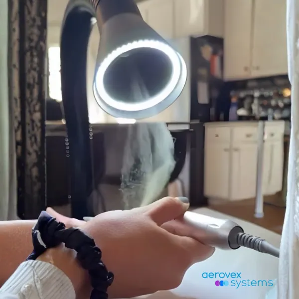 a nail technician using an e-file with the dust being sucked up by a ventilation system