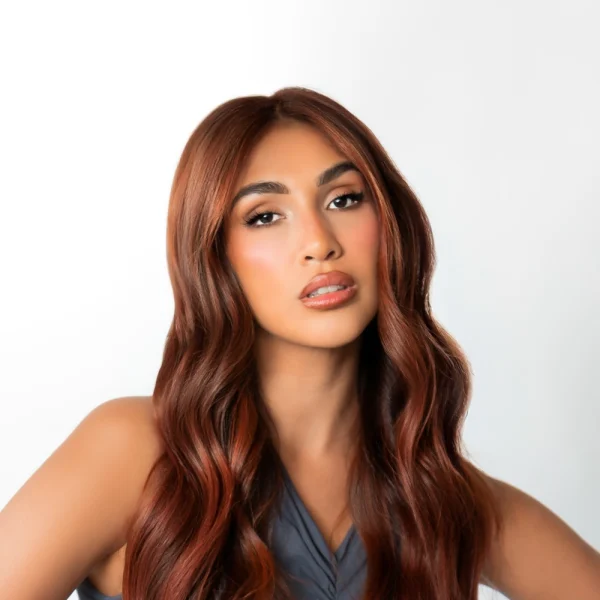 A model with long red hair, arms akimbo.