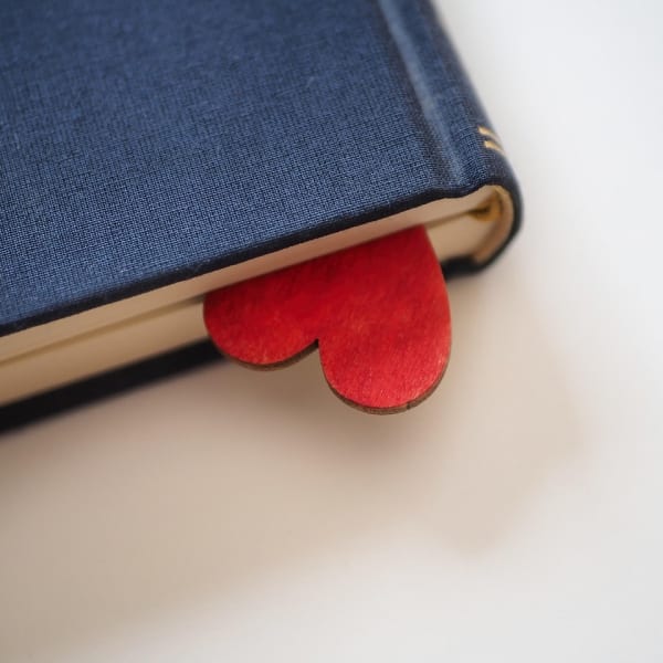 A book with a wooden heart tucked inside and peeking out