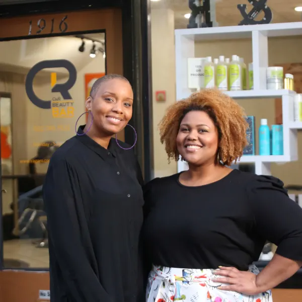 Owners Chenica Racine and Ricka O'Bannon outside the branded front door of their salon C&R Beauty Bar.