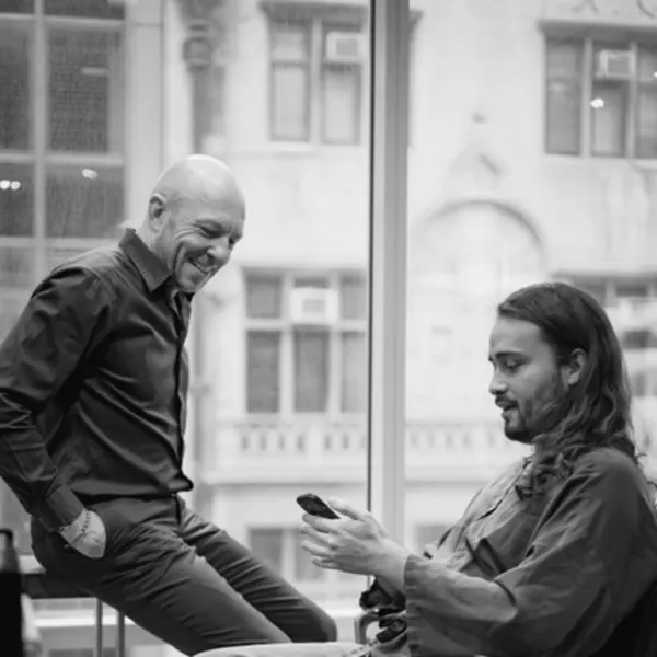 Two men talking and smiling, in profile.