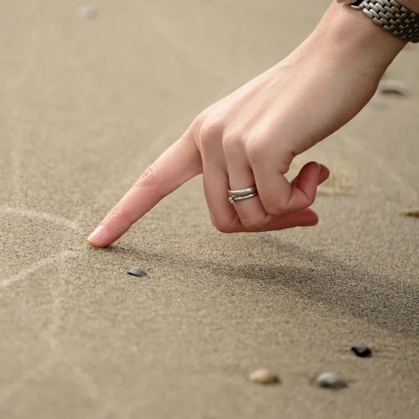 Drawing a heart in the sand.
