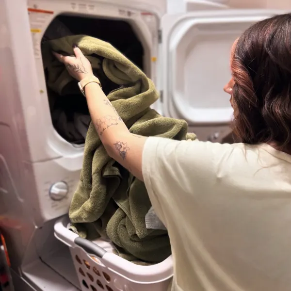 A stylist puts a load in the salon's washing machine.