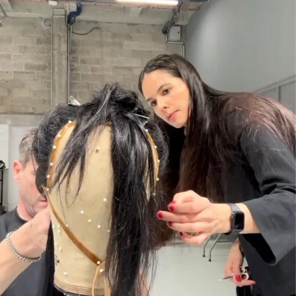 Michelle Bowden works on a hair piece on a mannequin