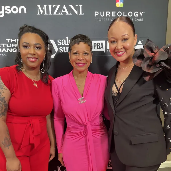 Nicole Johnson, Evie Johnson, and Jalia Pettis smile on the red carpet at the North American Hairstyling Awards.