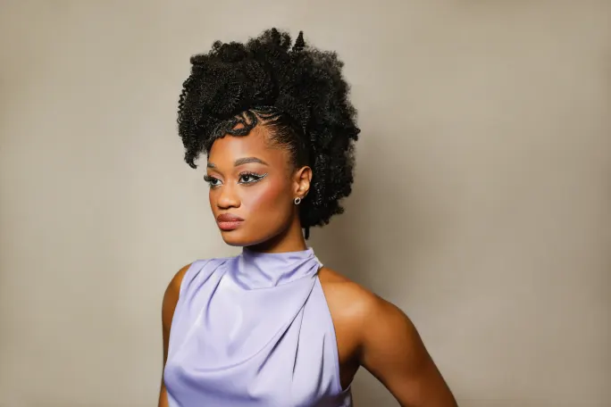 A woman in a lavender top with twisted and braided hair