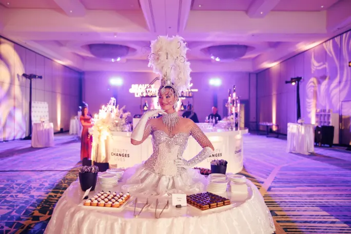 An elegant model emerges from a dessert table