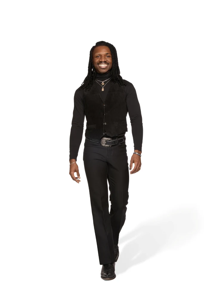A man with cornrows and in all black hair