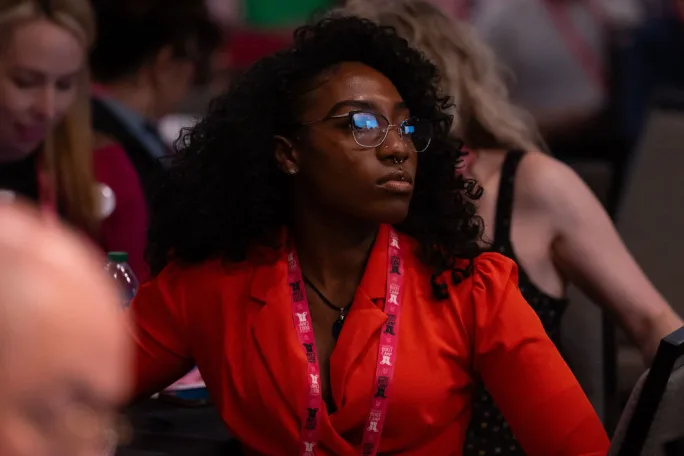 A woman listens to a presenter