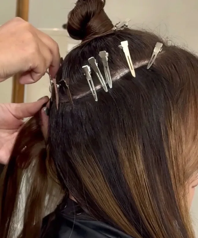 hands placing clips in brown hair