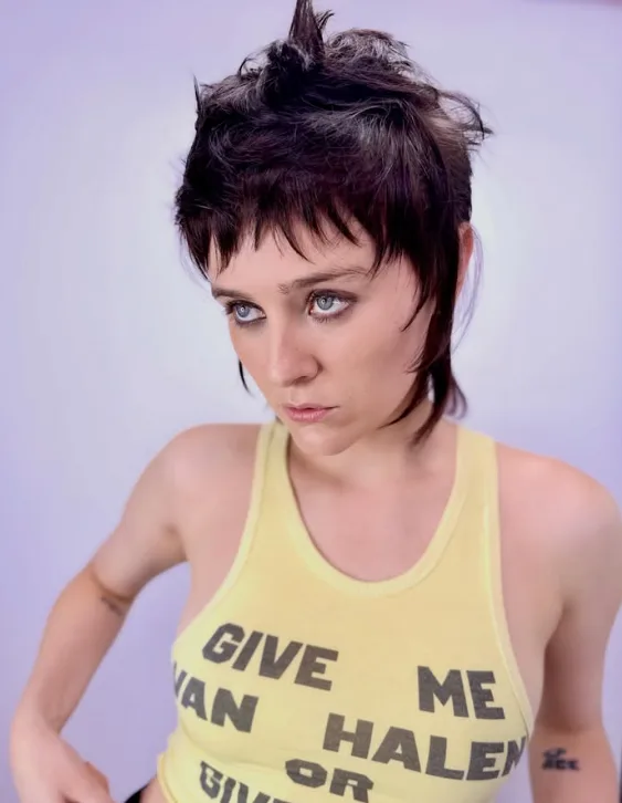 A woman in a yellow tshirt with short hair