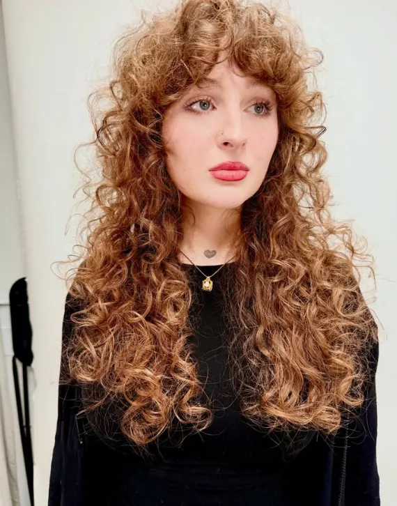 A young woman with very long and curly hair