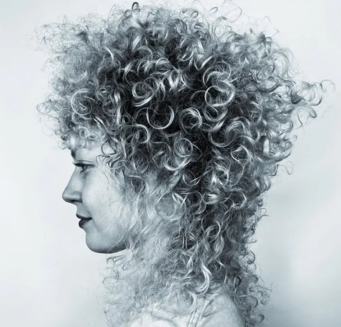 A woman in profile with curly hair