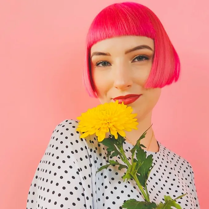 A  woman with a short pink bob