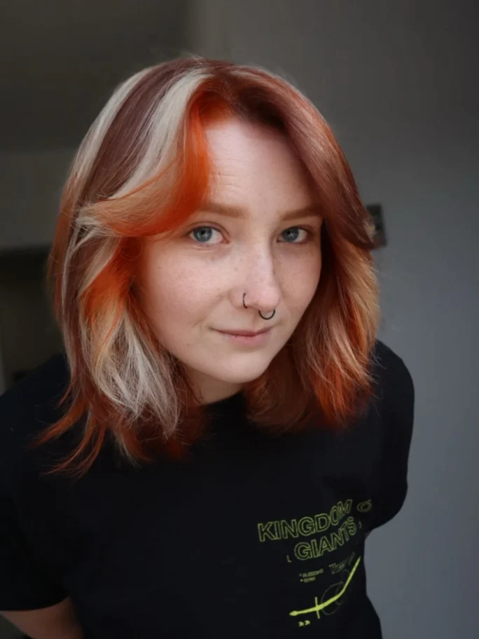 a woman with short red, brown and blonde hair