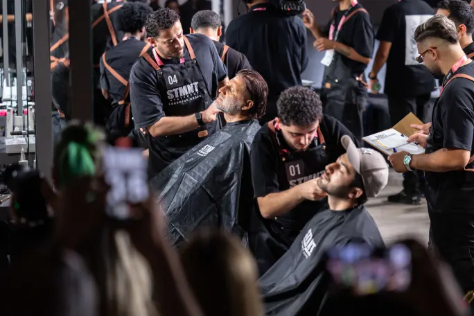 Several barbers work on several clients