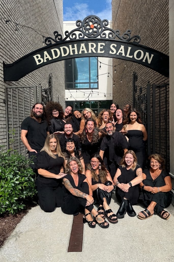 The team from Baddhare Salon gather under their sign.