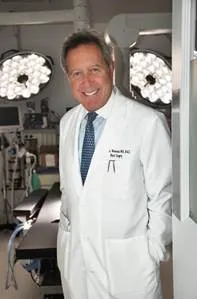 A smiling man in a white doctor's coat.