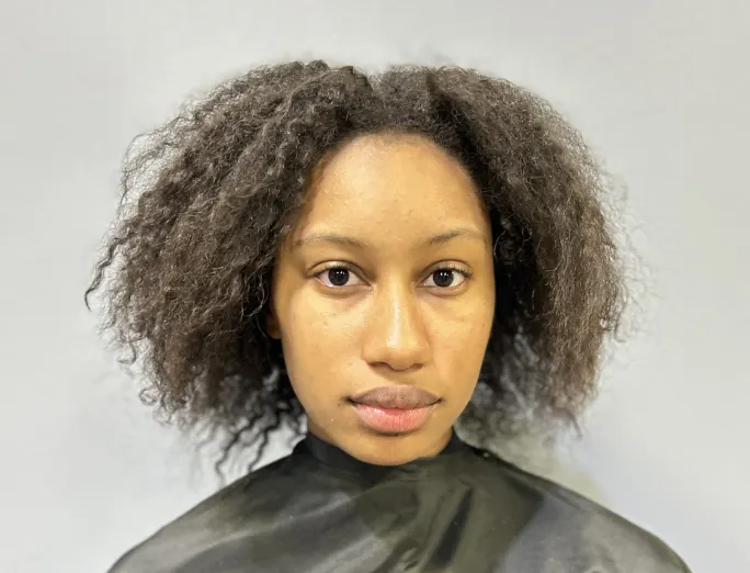A woman with dark, curly hair