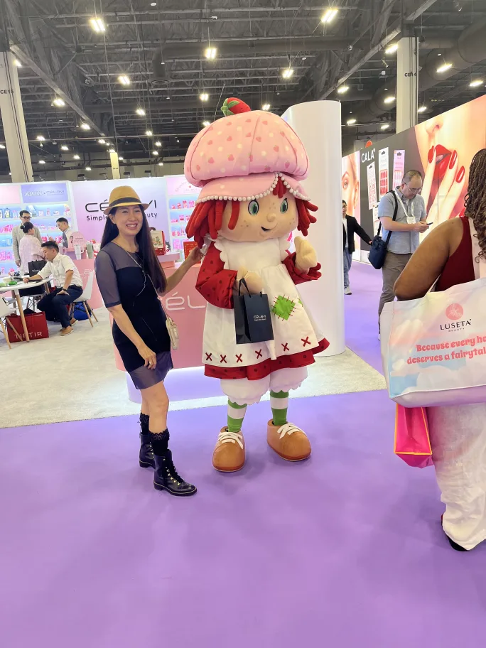 A woman standing next to a character dressed like a puppet