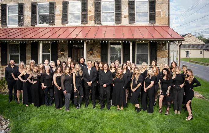 Posing outside in front of the salon, the large team from Decola Salon in Exton, Pennsylvania.