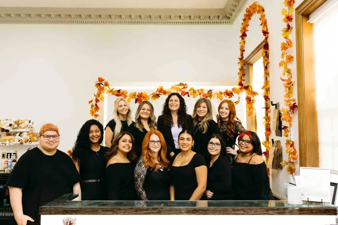 Dressed in black and posing behind the front desk, a team of stylists.