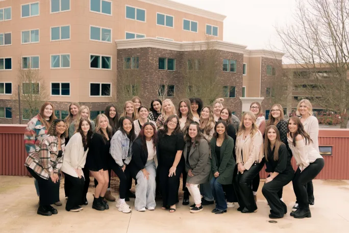Posing in front of commercial buildings, the team from Lonestar Salon & Spa.