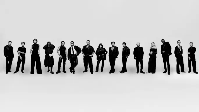 A row of standing men and women, all wearing black.