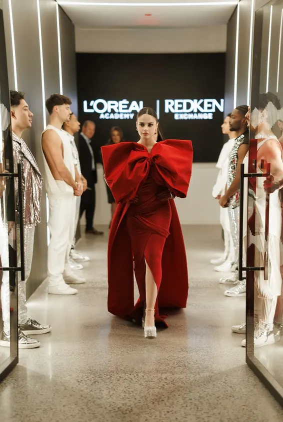 A model on a runway, wearing a red dress.