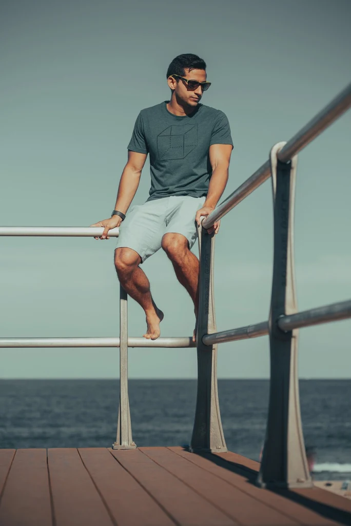 A man sitting on a fence railing.