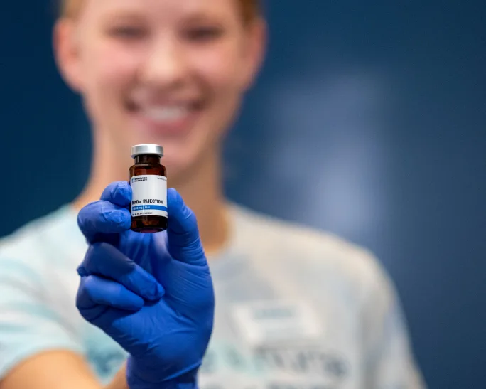 A medical technician holding a vial of NAD+