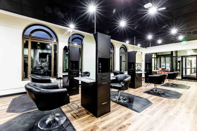 Black chairs face black stations in Origins Salon.