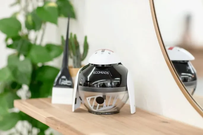 The penguin-like Ping X color mixer on a shelf in a salon next to a color brush stands ready to mix a color formula. 