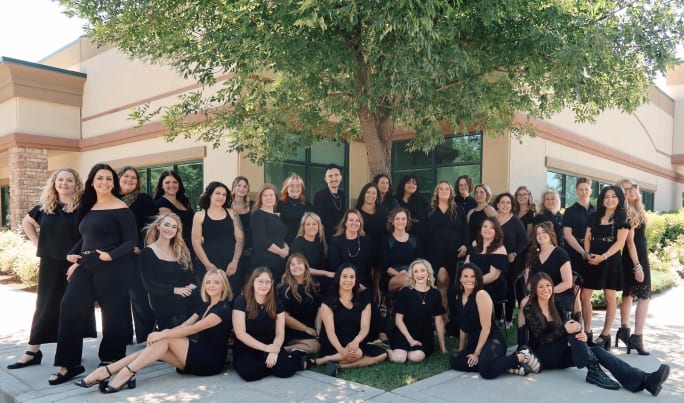 Gathering outside Rain Salon, team members pose all in black.