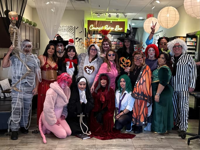 A large group of stylists in Halloween costumes gather at Salon Council.