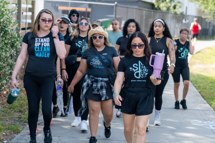 Wearing identical T shirts and bottles of water, a team of stylists participate in a charity walk.