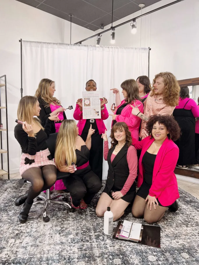 Employees dressed in pink point to the Salon Naman newsletter.