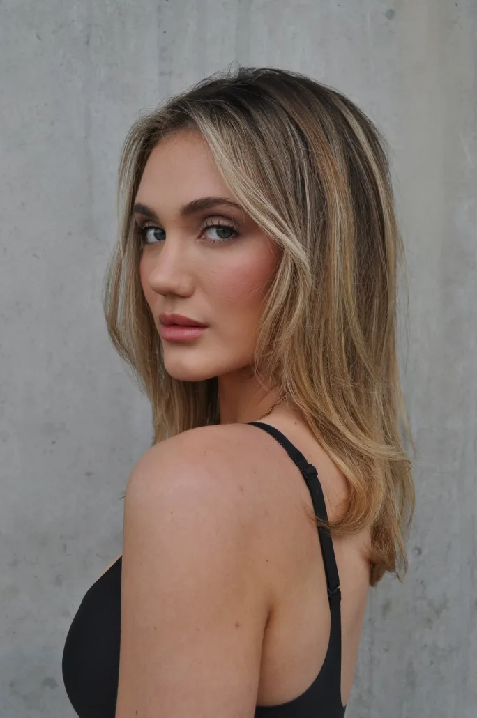 Young woman with medium-length, silky hair featuring multidimensional highlights and shine.